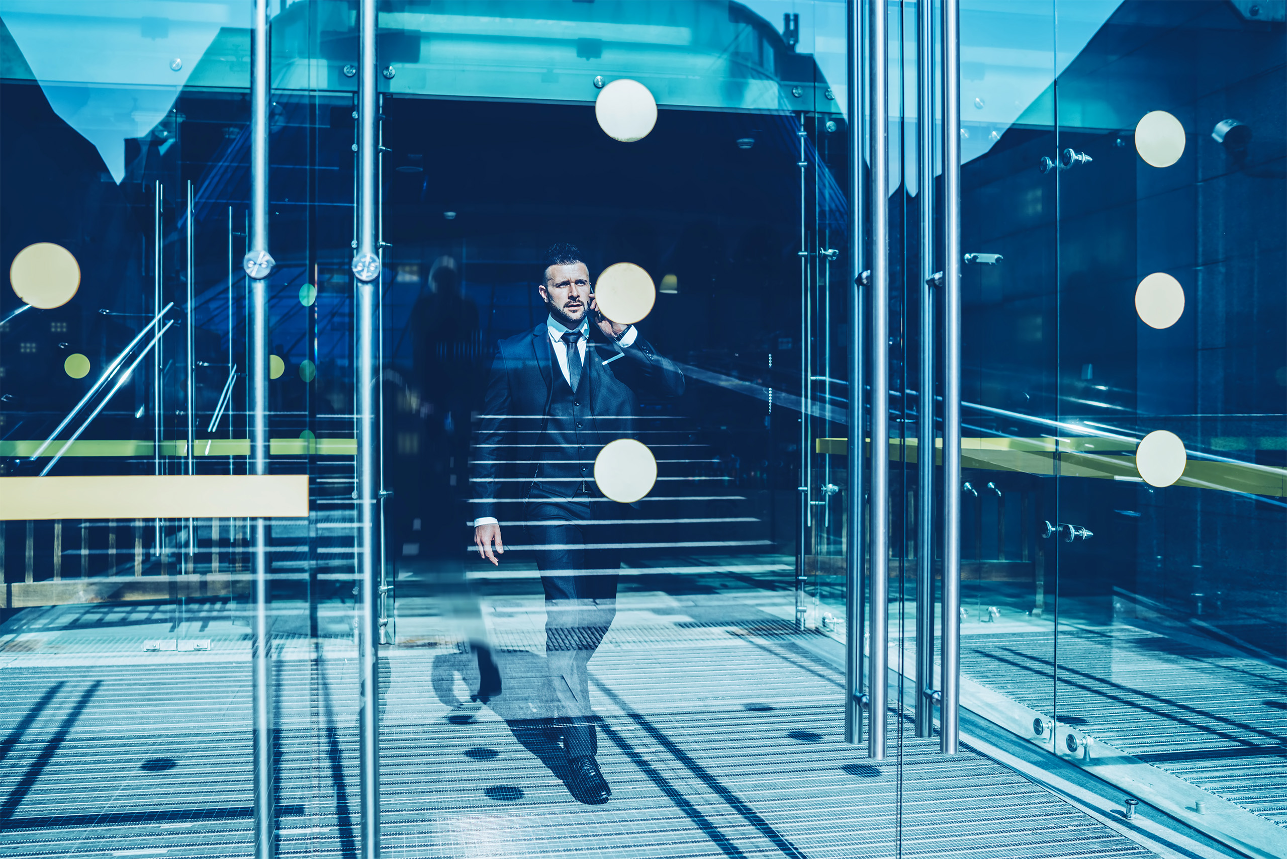 Man in suit exiting modern glass office building